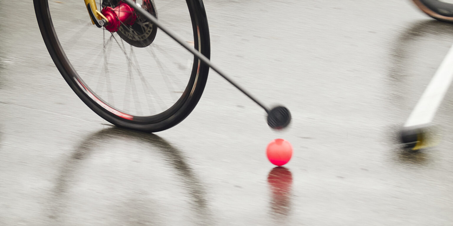 Photo d'une balle de bike polo sur un sol mouillé, poussée par un maillet.