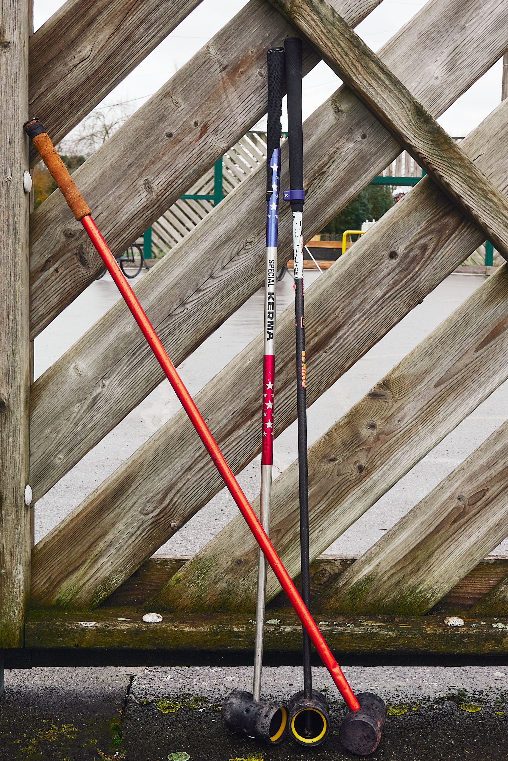 Photo de 3 maillets d ebike polo appuyés contre un mur en bois.